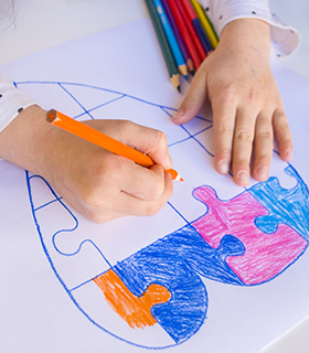 Student coloring in a heart on paper